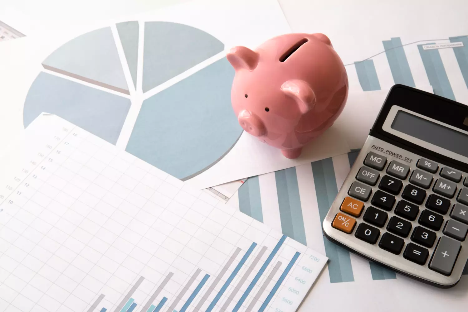 asesoría contable – gráfico financiero, hucha y calculadora sobre documentos fiscales
